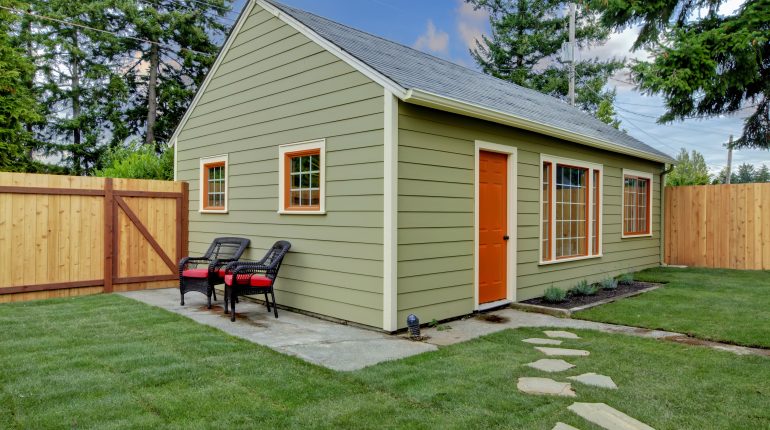 Small green and orange guest house in the back yard
