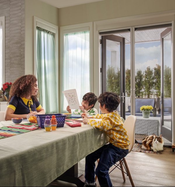 Family sitting at table with double doors with retractable door screens
